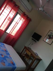 KpaliméBM Akwaba的一间卧室配有一张床、一张书桌和一个窗户。