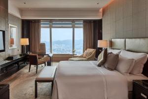 香港丽思卡尔顿酒店的酒店客房设有一张大床和一张书桌。