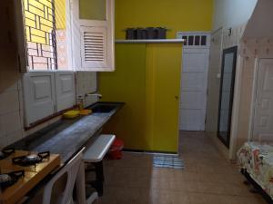 圣路易斯Kitnet Mobiliada的黄色的厨房,带有柜台和窗户