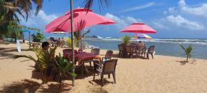 贝鲁沃勒森杜尔别墅酒店的海滩上带桌椅和遮阳伞的海滩