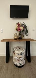 塞洛里库迪巴什图Villa Deluxe - Quinta do Outeirinho的一张带花瓶和椅子的木桌