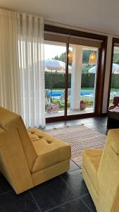 塞洛里库迪巴什图Villa Deluxe - Quinta do Outeirinho的带沙发的客厅,享有游泳池的景色