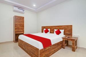 海得拉巴OYO Flagship 81135 Hotel R Square Inn的一间卧室配有一张带红色枕头的大床
