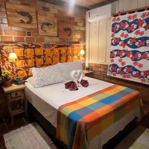 蜜岛普拉亚都法鲁旅馆的一间卧室配有一张带彩色毯子的床