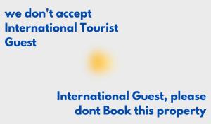 泗水Homey Guesthouse Kertajaya (Syariah)的附有标志,表示不接受国际游客预订该酒店。