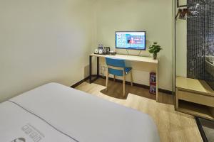 广州迎商酒店·广州市第一人民医院西门口地铁站店的客房设有一张床、一张书桌和电视