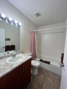 艾伯尼港雷德福德汽车旅馆的浴室配有盥洗盆、卫生间和浴缸。