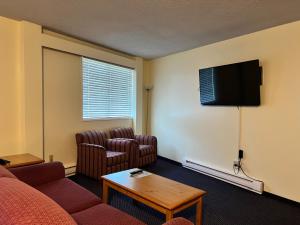艾伯尼港雷德福德汽车旅馆的客厅配有2把椅子和平面电视