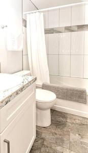 维多利亚Esquimalt Lagoon Life的白色的浴室设有卫生间、浴缸和水槽。