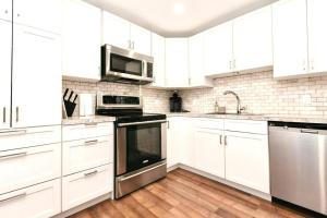 维多利亚Esquimalt Lagoon Life的白色的厨房,配有白色橱柜和不锈钢用具