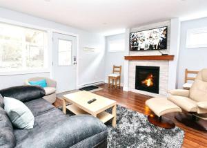 维多利亚Esquimalt Lagoon Life的带沙发和壁炉的客厅