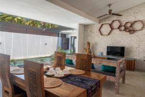 吉利特拉旺安吉利卡哈阳甘别墅度假村的一间带桌椅和电视的用餐室
