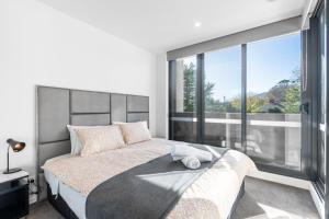 堪培拉Serain Residences Next to Canberra Centre的一间卧室设有一张大床和大窗户