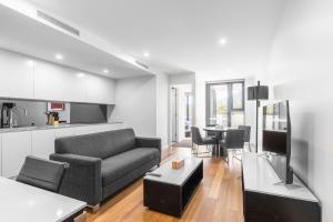堪培拉Serain Residences Next to Canberra Centre的客厅配有沙发和桌子