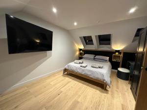 Laurieston Penthouse的一间卧室配有一张床和一台大电视