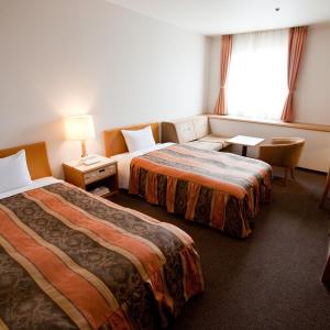 坂出市阪出格兰德酒店的酒店客房,设有两张床和一张沙发