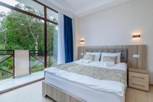 茨卡尔图博Vita Gardenia Hotel Tskaltubo的一间卧室设有一张大床和一个大窗户