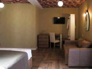 第比利斯Hotel BaniHills Tbilisi的酒店客房配有床、沙发和桌子。