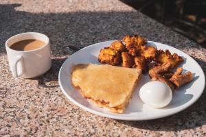 加德满都Nepalaya Home Hostel的鸡蛋和咖啡的盘子