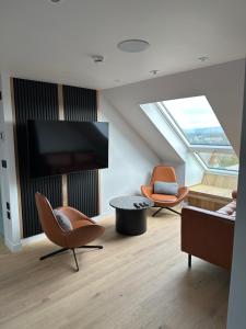 Laurieston Penthouse的客厅配有2把椅子和平面电视