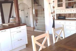 Oberglatt3 Bedroom Swiss House on 3 Floors的厨房配有白色橱柜和桌椅