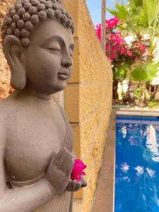内尔哈Boutique Hostal Lorca的游泳池旁一朵花的女人的雕像