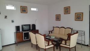 巴图In Villa Garden Resort的客厅配有桌椅和电视。