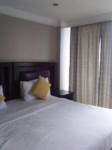 德班Three and two bedroom at The Sails的卧室配有一张带黄色枕头的大型白色床。