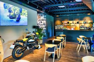 班斯卡-比斯特里察SINATRA CIGAR HOUSE的停放在配有桌椅的餐厅的摩托车