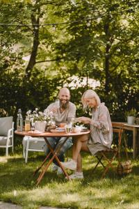 索普拉布扎诺Villa Gloria的两个人坐在草地上的桌子上