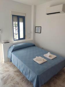 圣何塞Habitacion 1 o 2 personas的一间卧室配有蓝色的床和2条毛巾