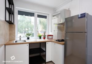 RoşuAvangarde Concept Studio的厨房配有白色橱柜和不锈钢冰箱