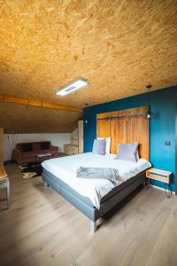 克莱恩 蒙塔纳B&B La Forge de Diogne的一间卧室设有一张带木制天花板的大床