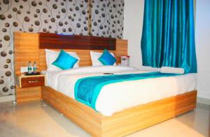 新德里Royal Punjab in的一间卧室配有一张带蓝色窗帘的大床