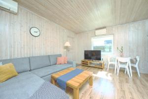 库雷萨雷Family retreat with a sauna in the centre的带沙发、桌子和电视的客厅