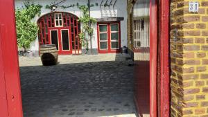埃尔斯洛Boerderijwoning Elsloo的大楼前有一扇红色门,有桶