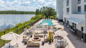 迈尔斯堡Crowne Plaza Ft Myers Gulf Coast, an IHG Hotel的户外庭院设有游泳池、桌子和遮阳伞。