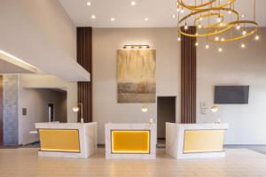 迈尔斯堡Crowne Plaza Ft Myers Gulf Coast, an IHG Hotel的大堂设有2把黄色椅子和吊灯