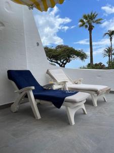 莫甘Apartamento Puerto Rico - Primera línea de playa的庭院里摆放着几把椅子
