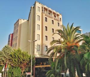 伊斯坦布尔东方敏特尔酒店的一座高大的建筑,前面有一棵棕榈树