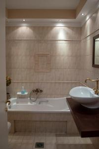 伊里斯斯Αλσύλλιο - Alsillio studio apartments的带浴缸和盥洗盆的浴室