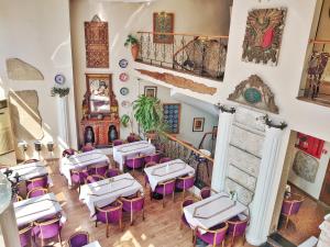 伊斯坦布尔东方敏特尔酒店的餐厅配有白色桌子和紫色椅子