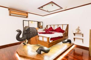 清迈Olivier Boutique的一间卧室配有一张带大象椅的床