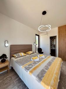 蒂瓦特Adriatic Dream的一间卧室配有一张大床,床上配有黄色毛巾
