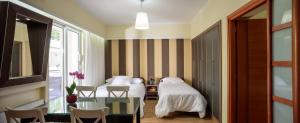 雅典Lume Athens的一间卧室配有两张床和一张桌子及椅子