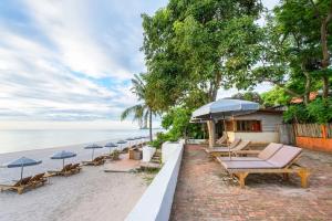 华欣瓦兰达洛奇酒店的海滩上一排椅子和遮阳伞
