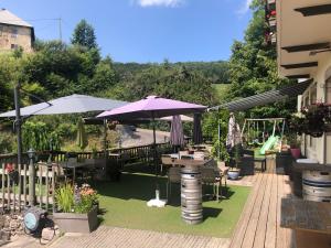 莱代塞尔玛哲丽艾酒吧、酒店及餐厅的草坪上带桌子和遮阳伞的庭院