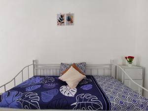 日惹Ambarukmo Green Hill / MA 8的一间卧室配有一张带蓝色和白色床单的床。