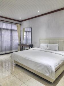 巴图In Villa Garden Resort的卧室配有一张白色的大床和一张桌子