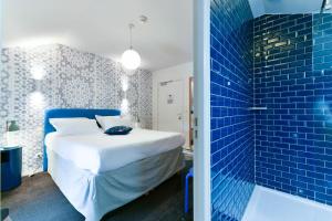 阿斯帕朗爱吉亚酒店的一间卧室设有一张床和蓝色瓷砖墙